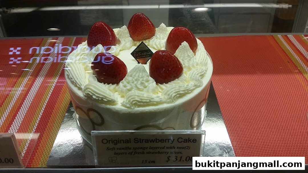 A beautifully decorated strawberry cake with whipped cream and fresh strawberries.
