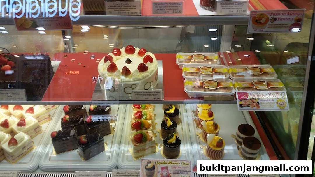 A display case filled with various cakes and pastries, including strawberry cakes and chocolate desserts.