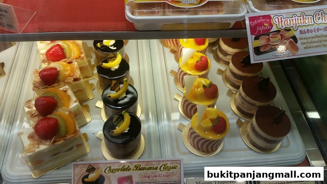 A display case filled with various beautifully decorated cakes and pastries.