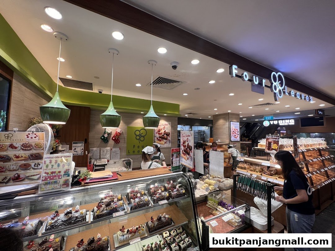 Interior view of a bakery with display cases filled with cakes and pastries.