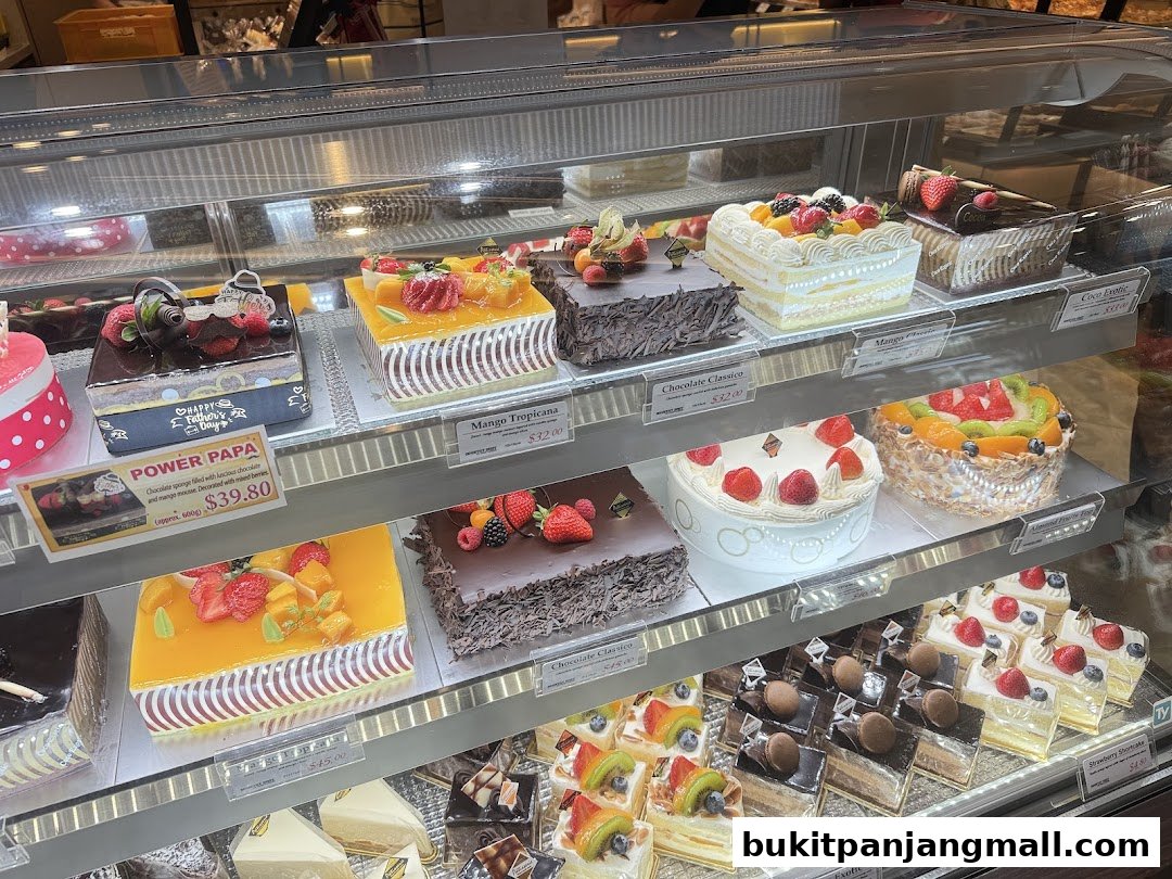 A display case filled with a variety of beautifully decorated cakes and pastries.