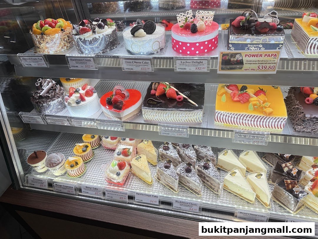 A display case filled with a variety of beautifully decorated cakes and pastries.