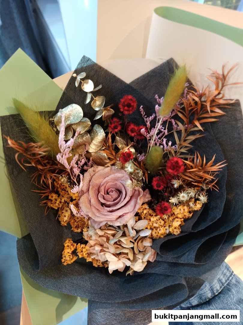 A beautifully arranged bouquet of dried flowers with a vintage rose and golden eucalyptus.