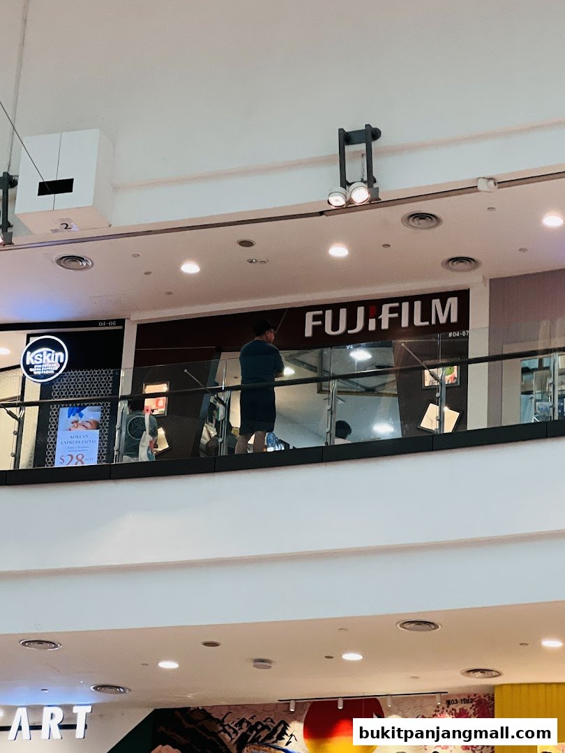 The Fujifilm store is visible with its prominent signage and a person standing in front of it.