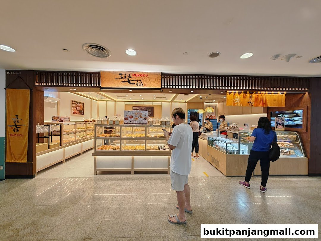 Customers browse baked goods at Gokoku Japanese Bakery, showcasing a wide selection of breads and pastries.