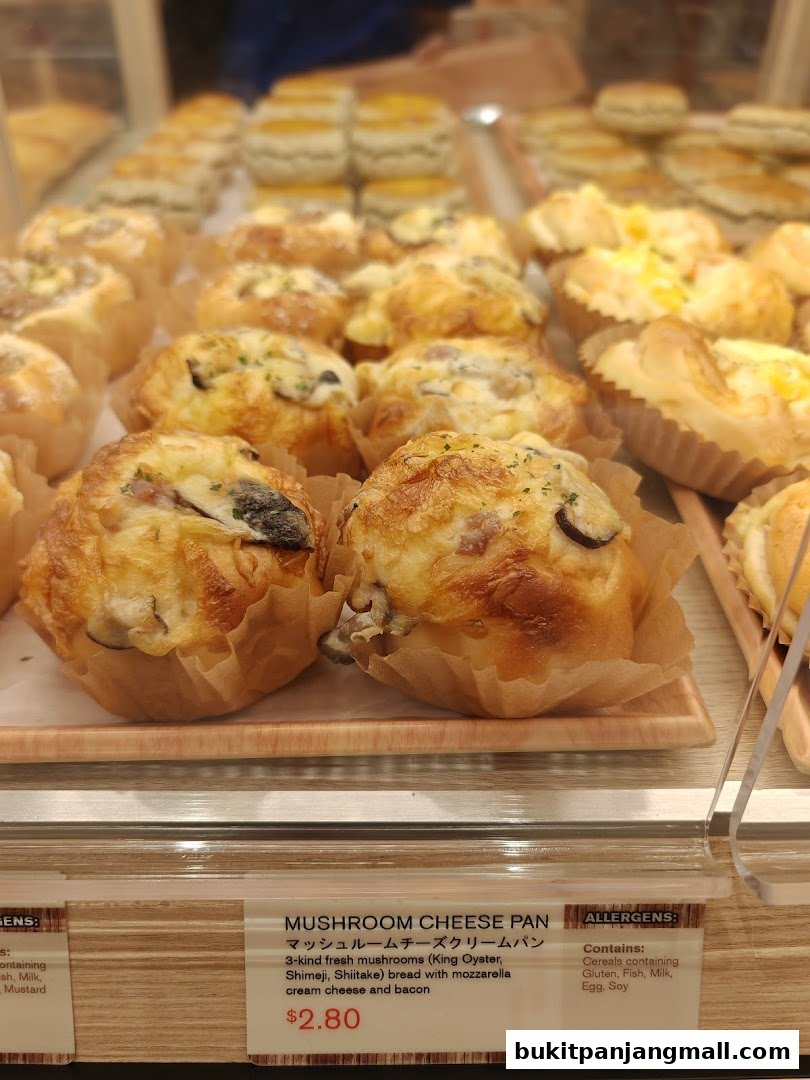 A close-up view of freshly baked mushroom cheese bread rolls at a bakery.