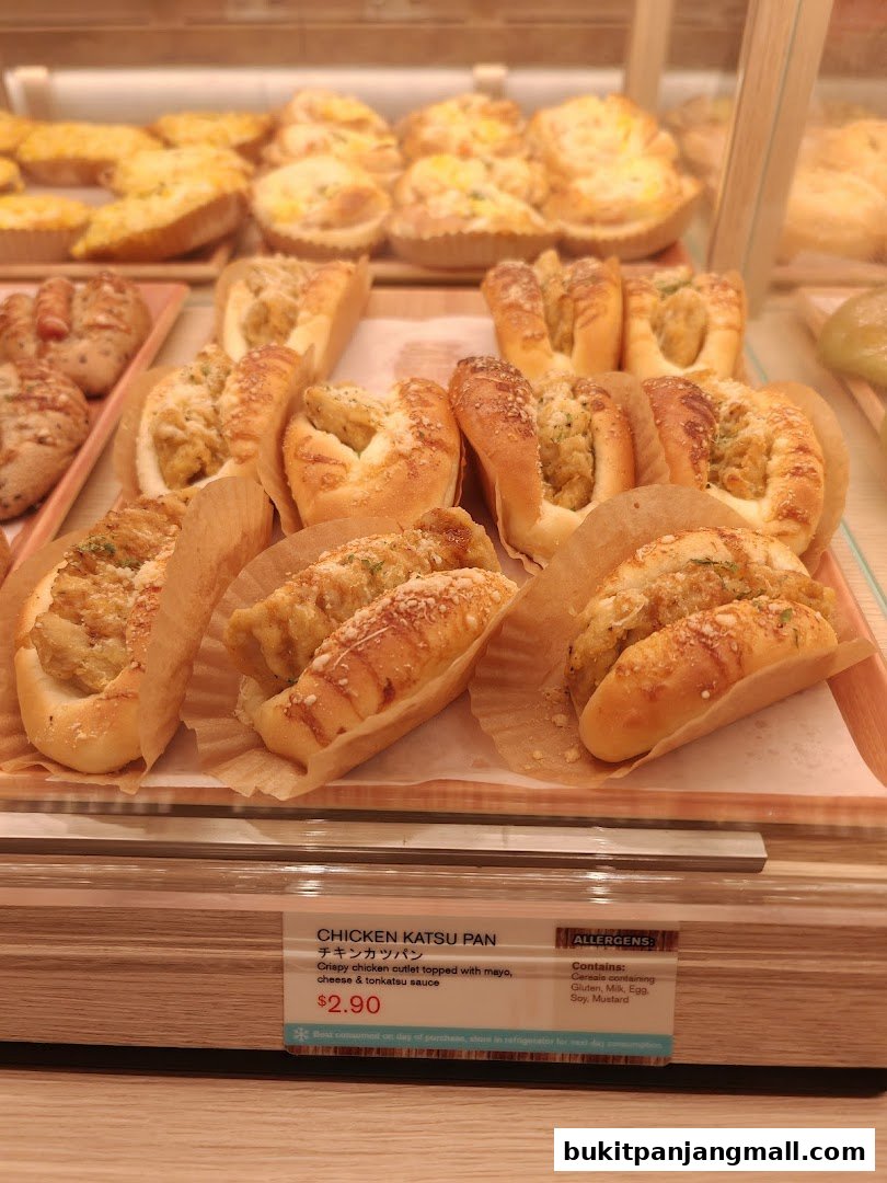 A display of freshly baked Japanese-style bread, featuring chicken katsu pan.