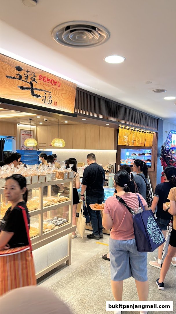 Customers queue at Gokoku Japanese Bakery, with a display of fresh bread and pastries.