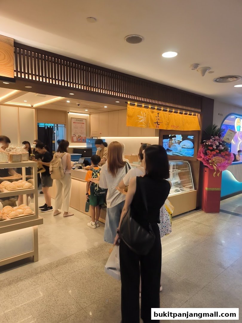 Customers queue at Gokoku Japanese Bakery, with fresh bread displayed in a glass case.