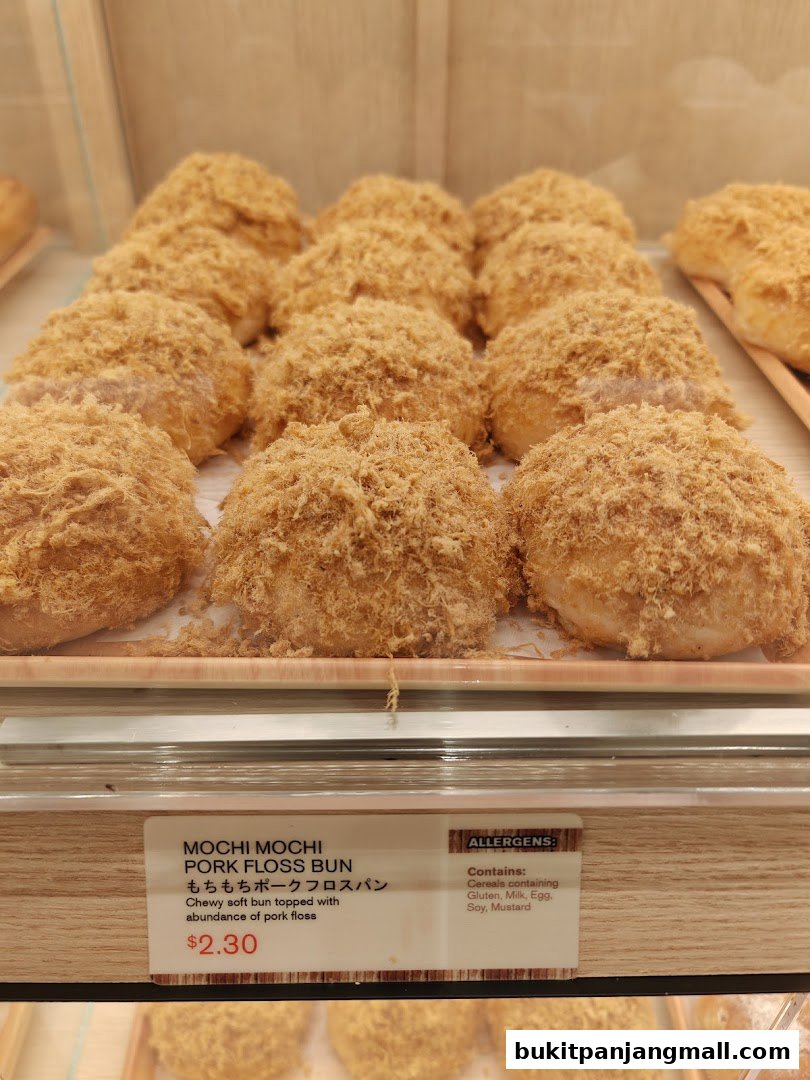 A close-up of Mochi Mochi Pork Floss Buns displayed in a bakery case.