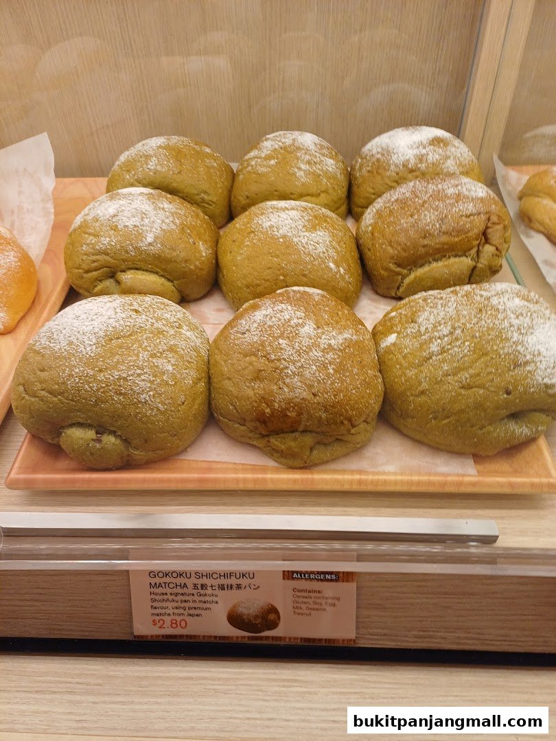 A display of freshly baked matcha flavored buns dusted with powdered sugar.