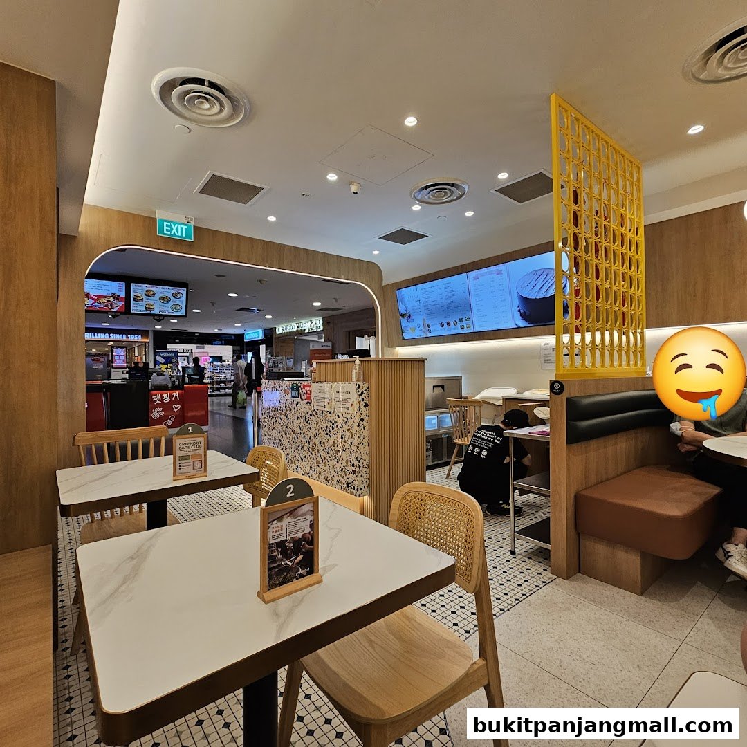 Interior view of Greendot restaurant with tables, chairs, and a digital menu board.