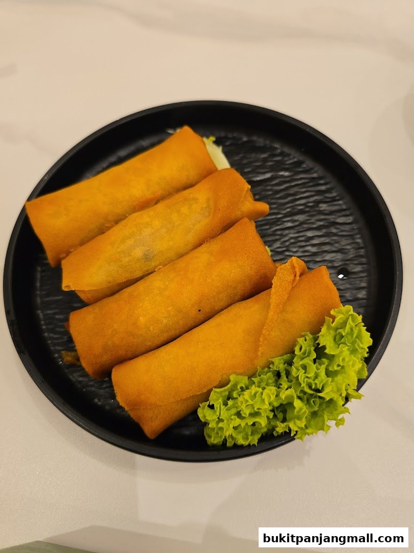 A plate of golden-brown spring rolls served with fresh lettuce.