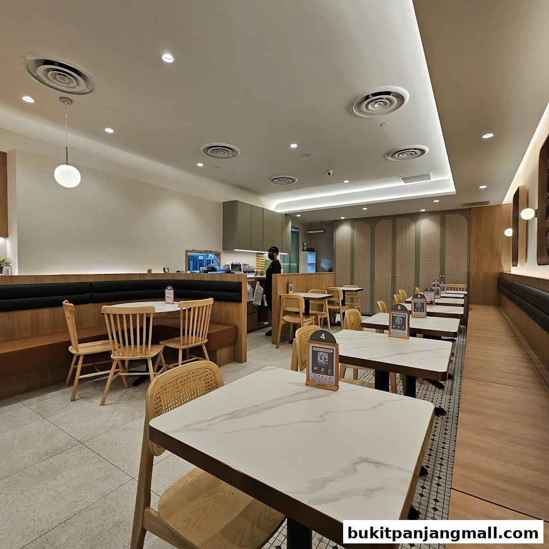 Interior view of a Greendot restaurant with tables, chairs, and a staff member.