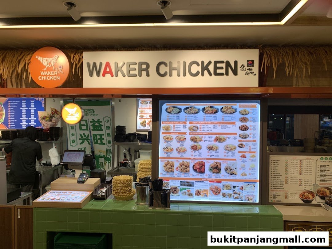 A brightly lit food stall counter with a large menu display and a worker preparing food.