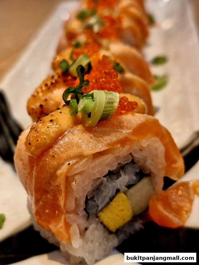 A close-up of delicious salmon sushi rolls topped with tobiko and green onions.