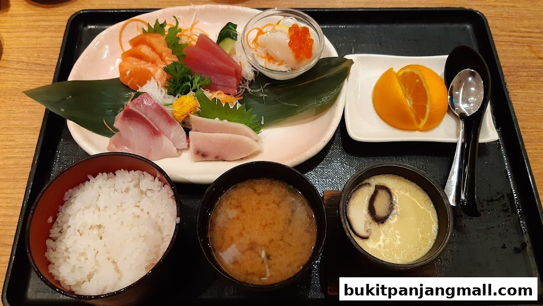 A Japanese meal set featuring sashimi, rice, miso soup, and chawanmushi.