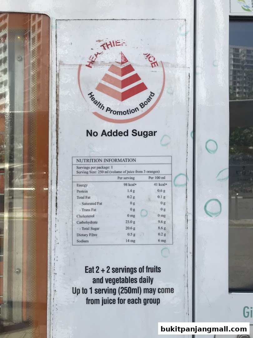 A nutrition label on a juice machine highlights 'No Added Sugar' and serving information.