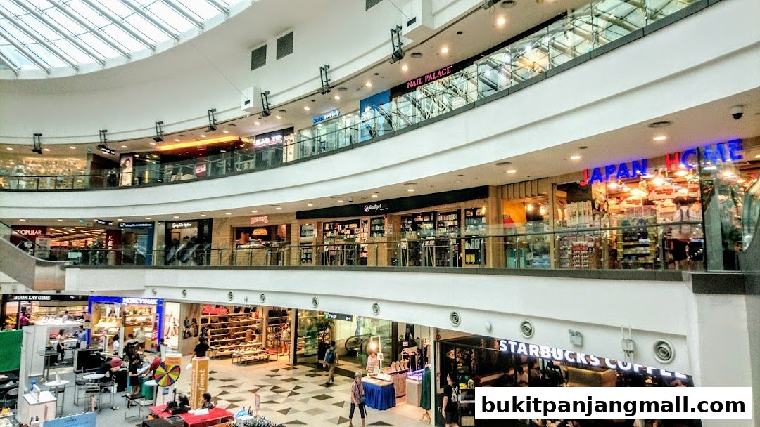 Interior view of a multi-level shopping mall with various shops visible.