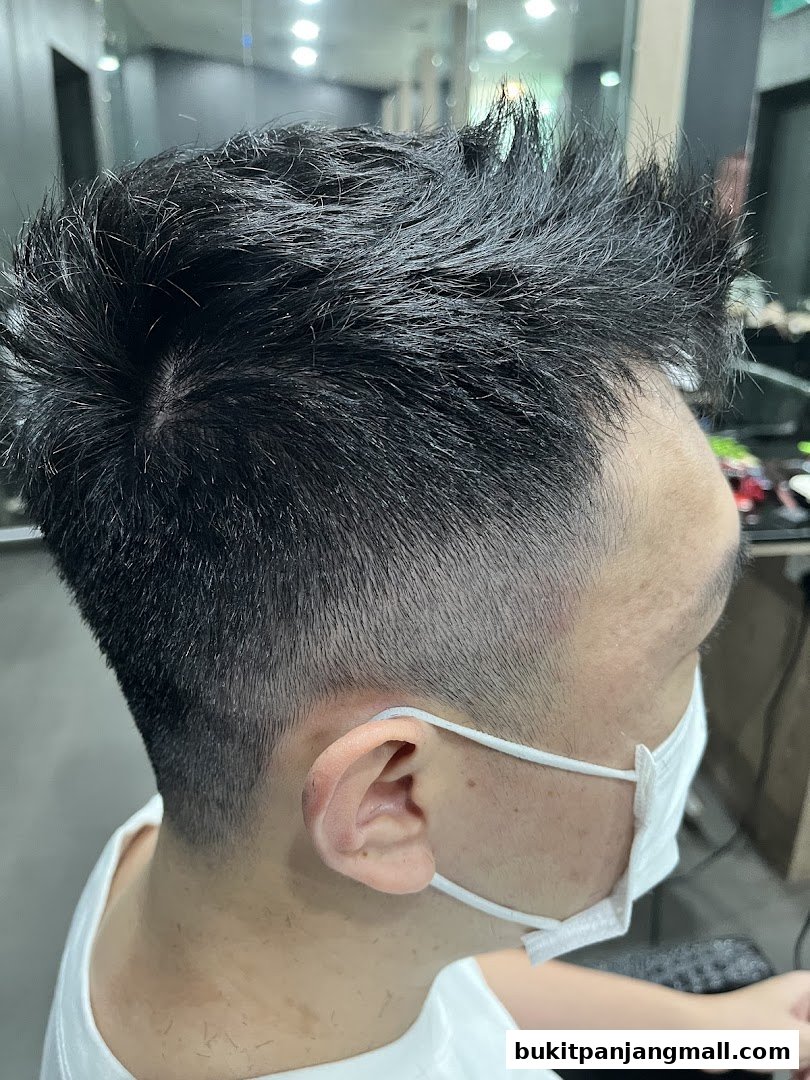 Close-up of a person's haircut with styled, spiky hair and a fade on the sides.