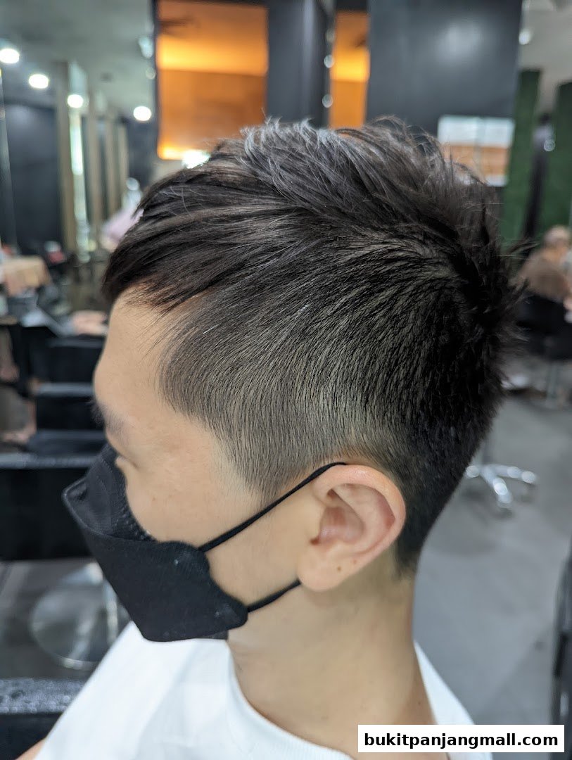A close-up of a man's stylish haircut with a black mask.