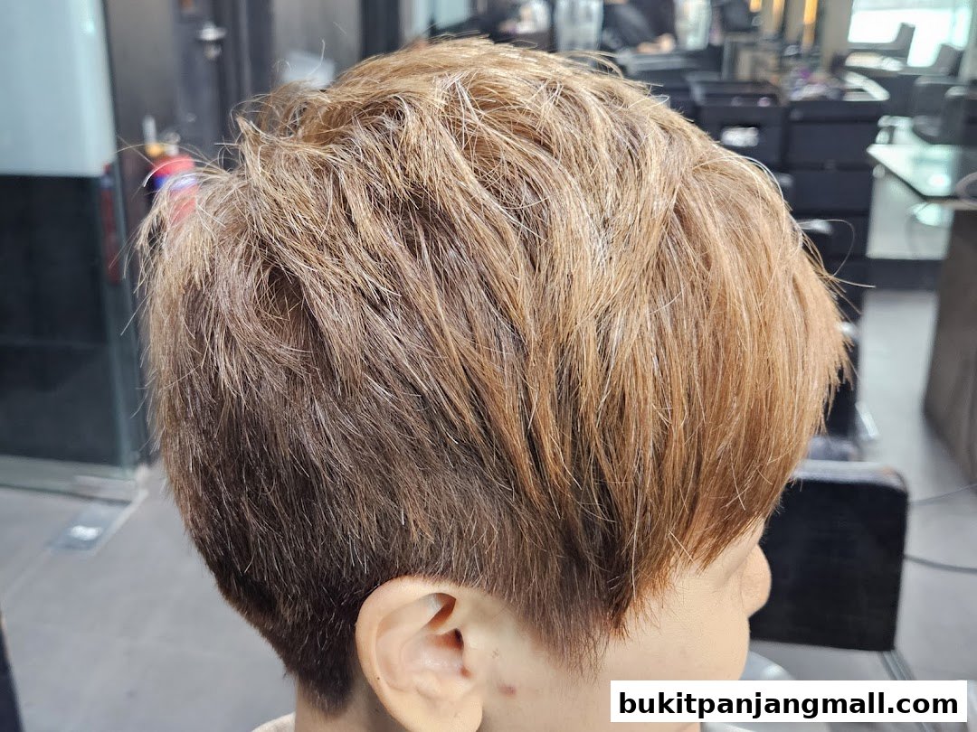 A close-up view of a person's short, layered, blonde-highlighted hairstyle.
