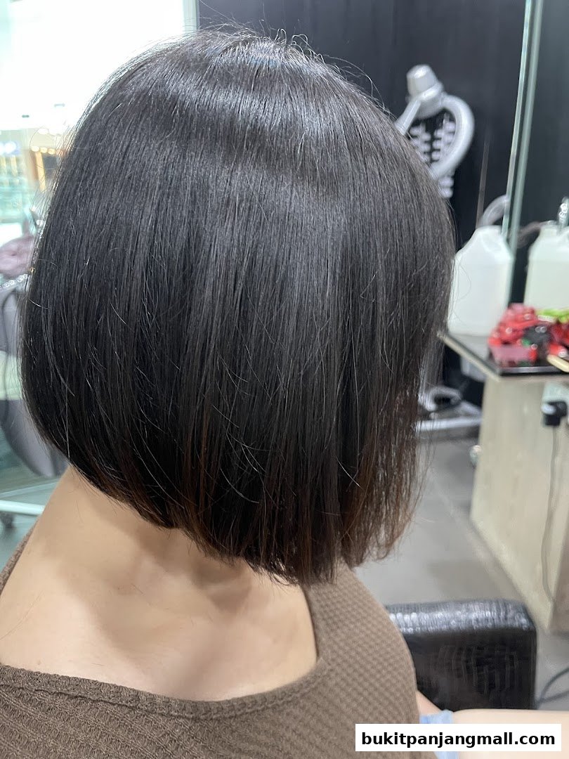 A woman with a fresh bob haircut in a salon.