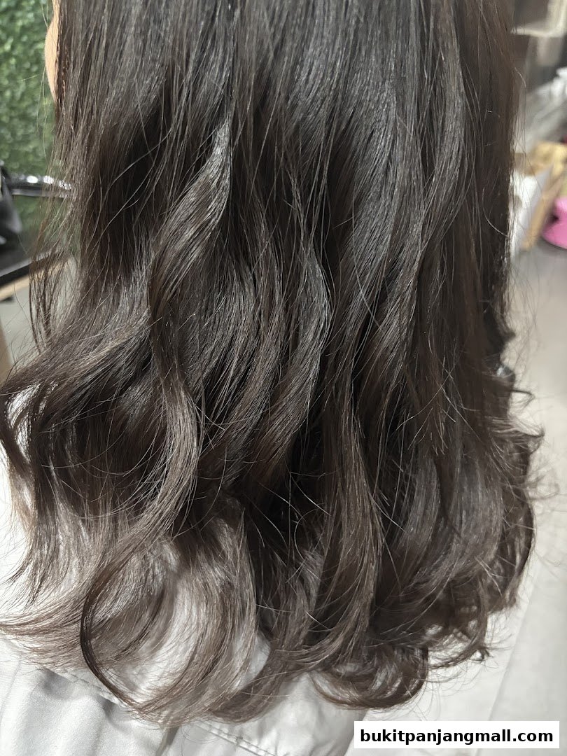 Close-up of a person's dark, wavy hair with subtle highlights.