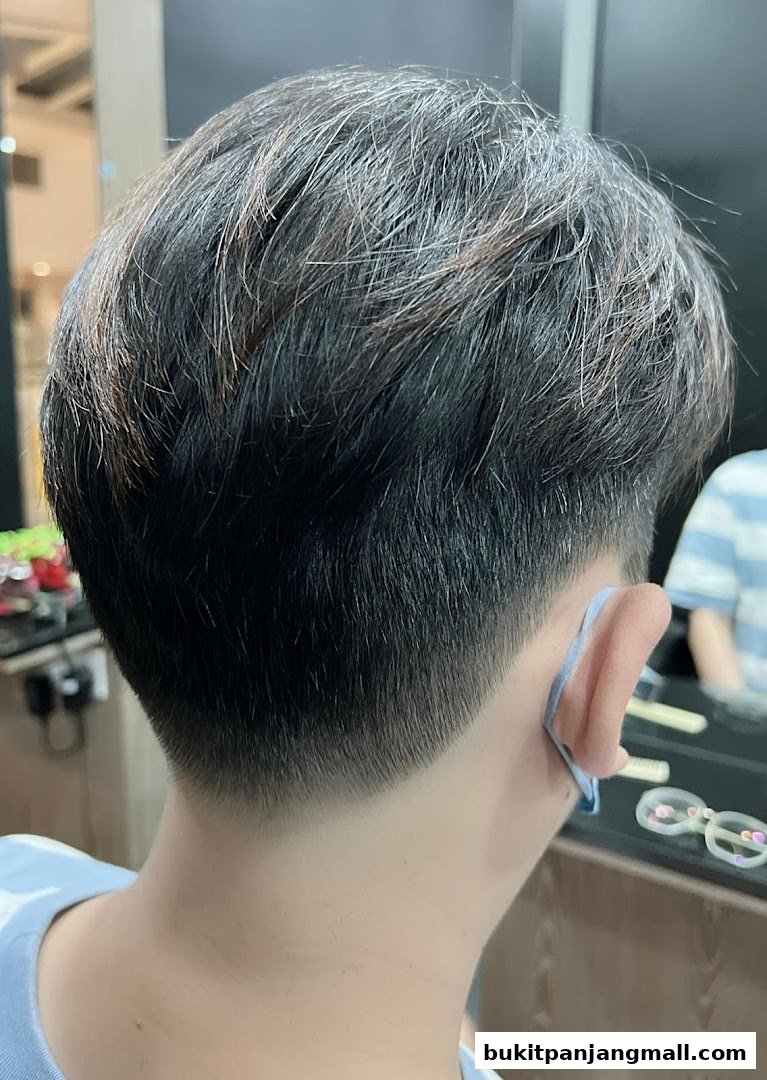 Close-up of a person's neatly styled hair with a fade at the nape.