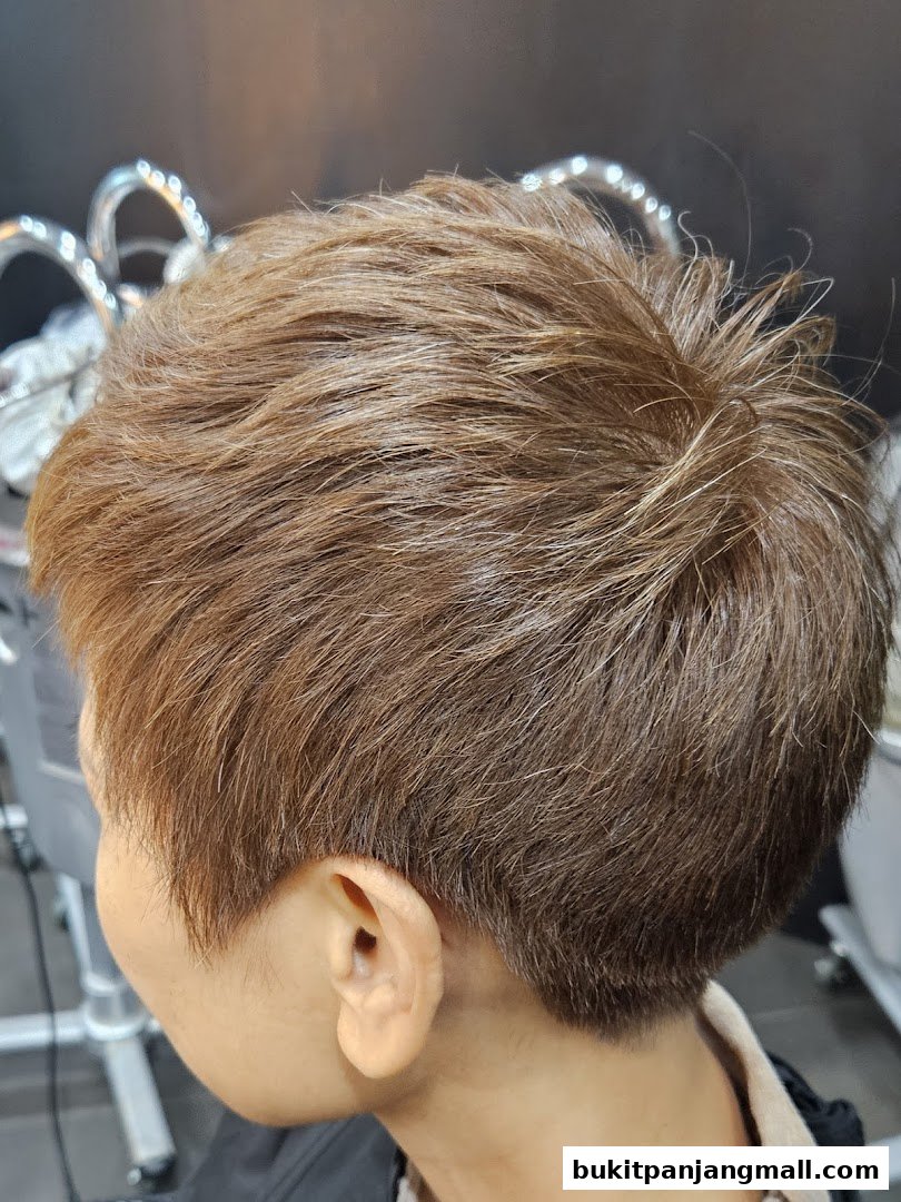 A close-up side view of a person's short, brown, layered haircut.