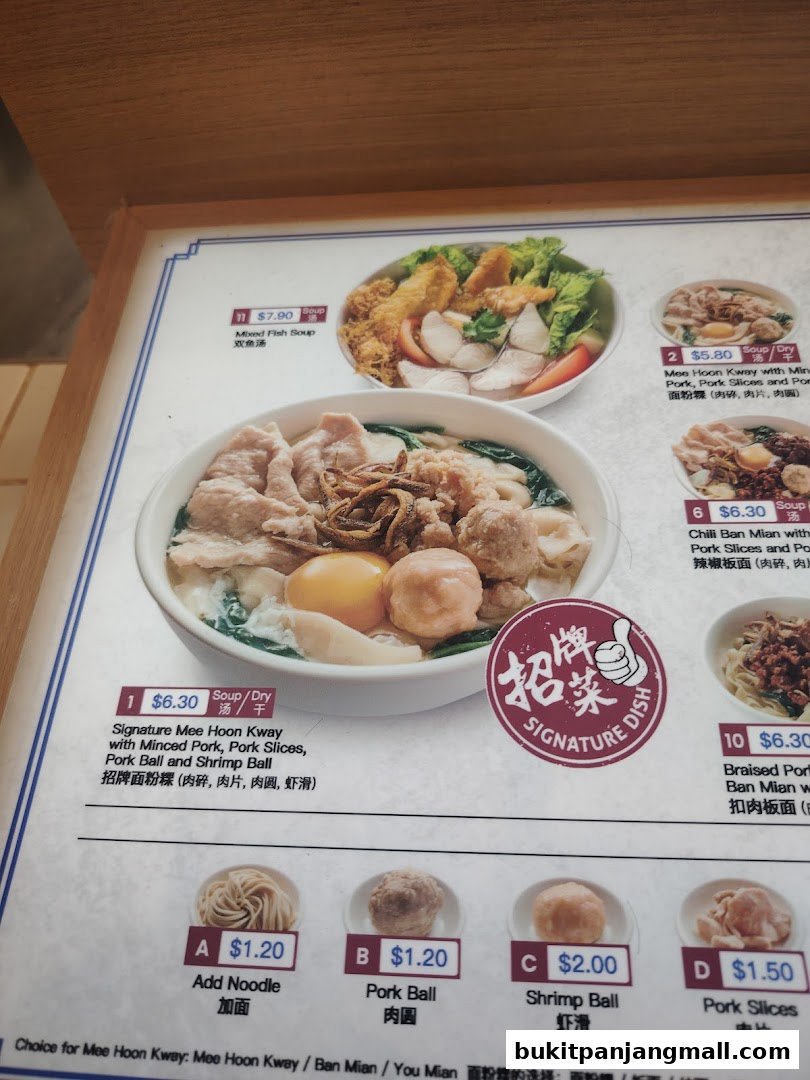 A close-up of a menu board displaying various noodle dishes and side options.