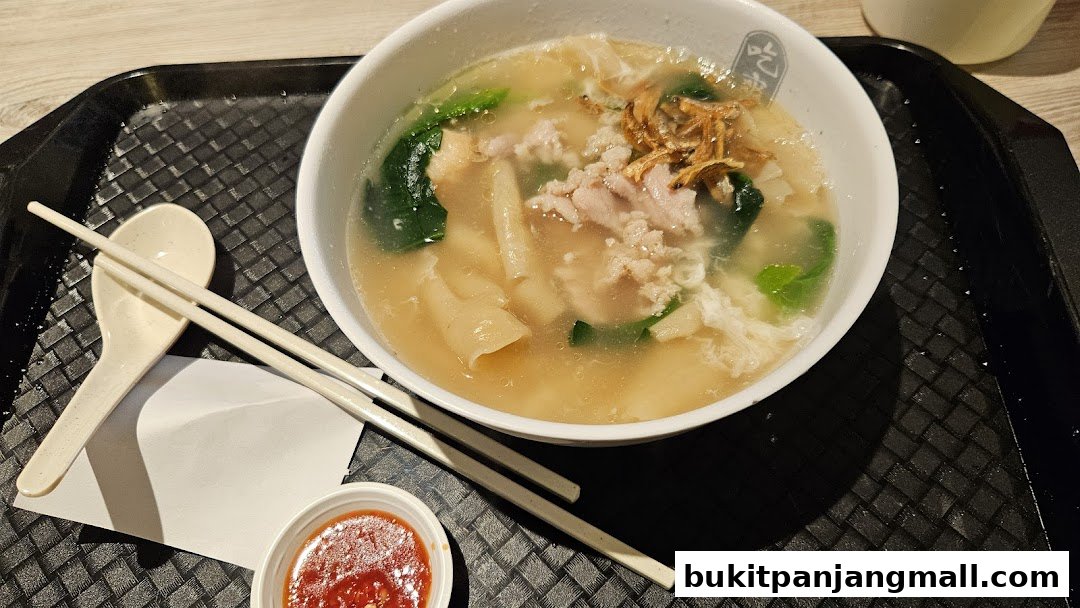 A bowl of Mee Hoon Kway soup with minced pork, vegetables, and fried shallots.