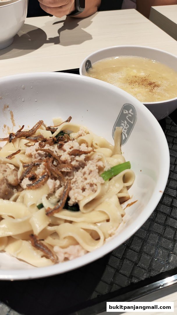 A close-up of a bowl of Mee Hoon Kway noodles with minced meat and fried anchovies.
