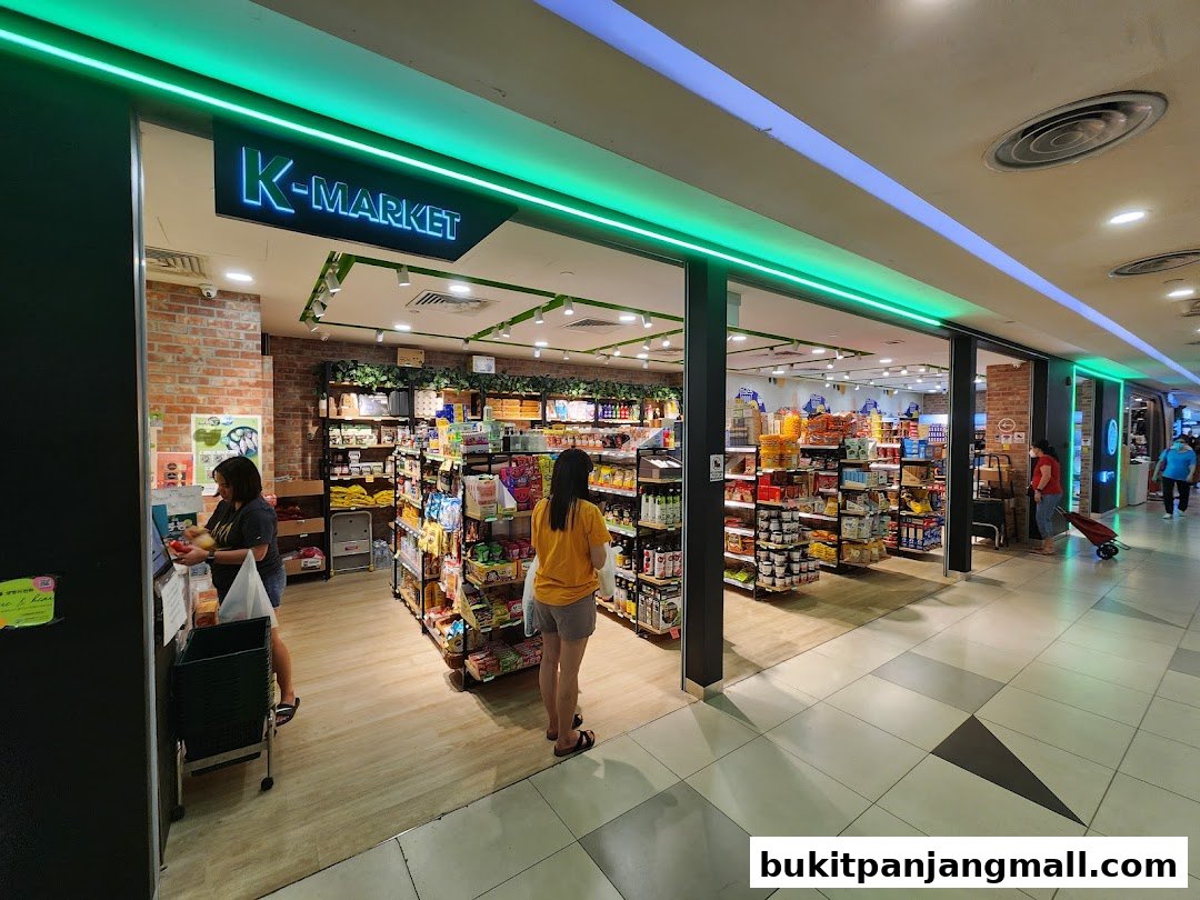 The entrance of K-market Koryo Mart, showcasing shelves stocked with various products and customers browsing.