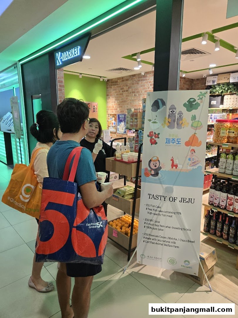 People are looking at a promotional banner for Jeju products at K-Market.