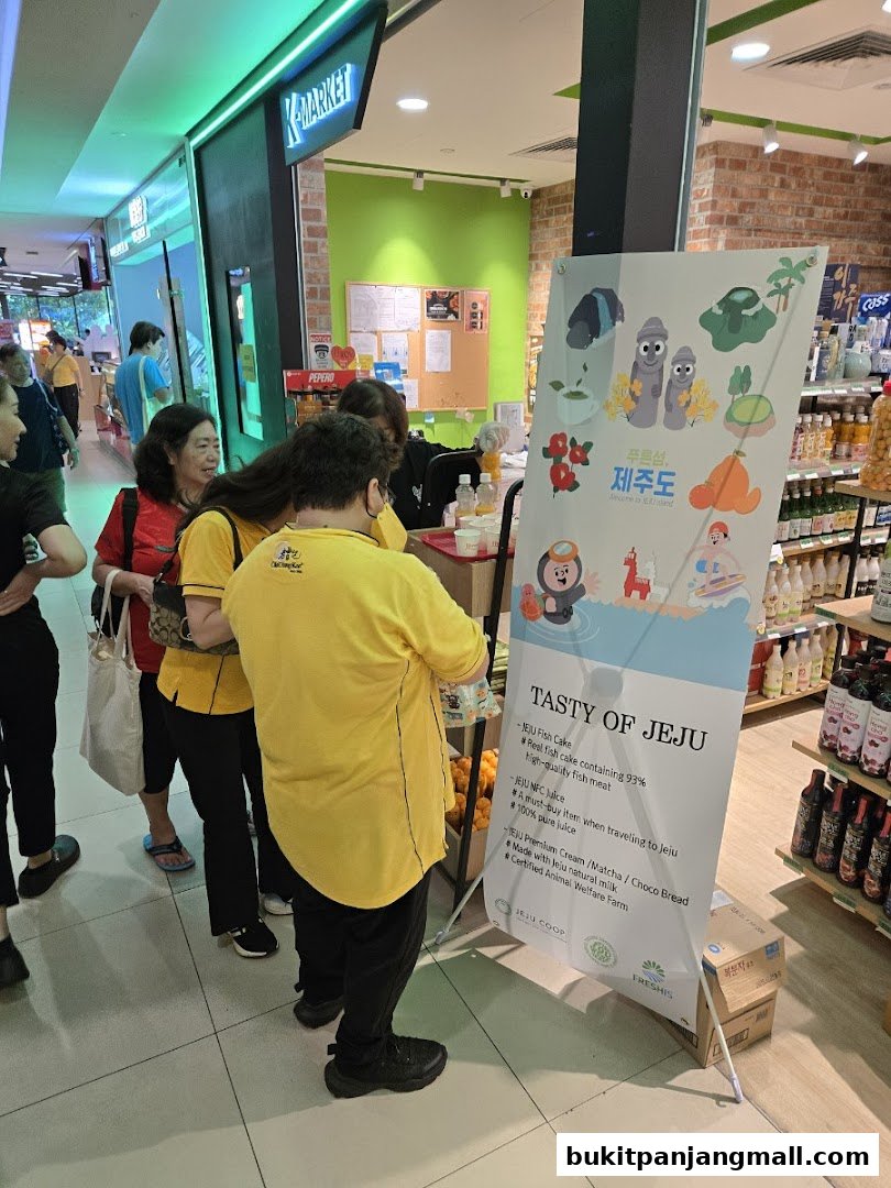 People queuing at K-market Koryo Mart, with a promotional banner for Jeju products.