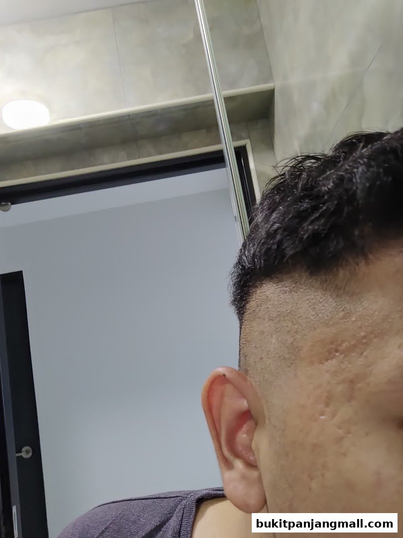 Close-up of a person's ear and side of their head, showing a haircut.