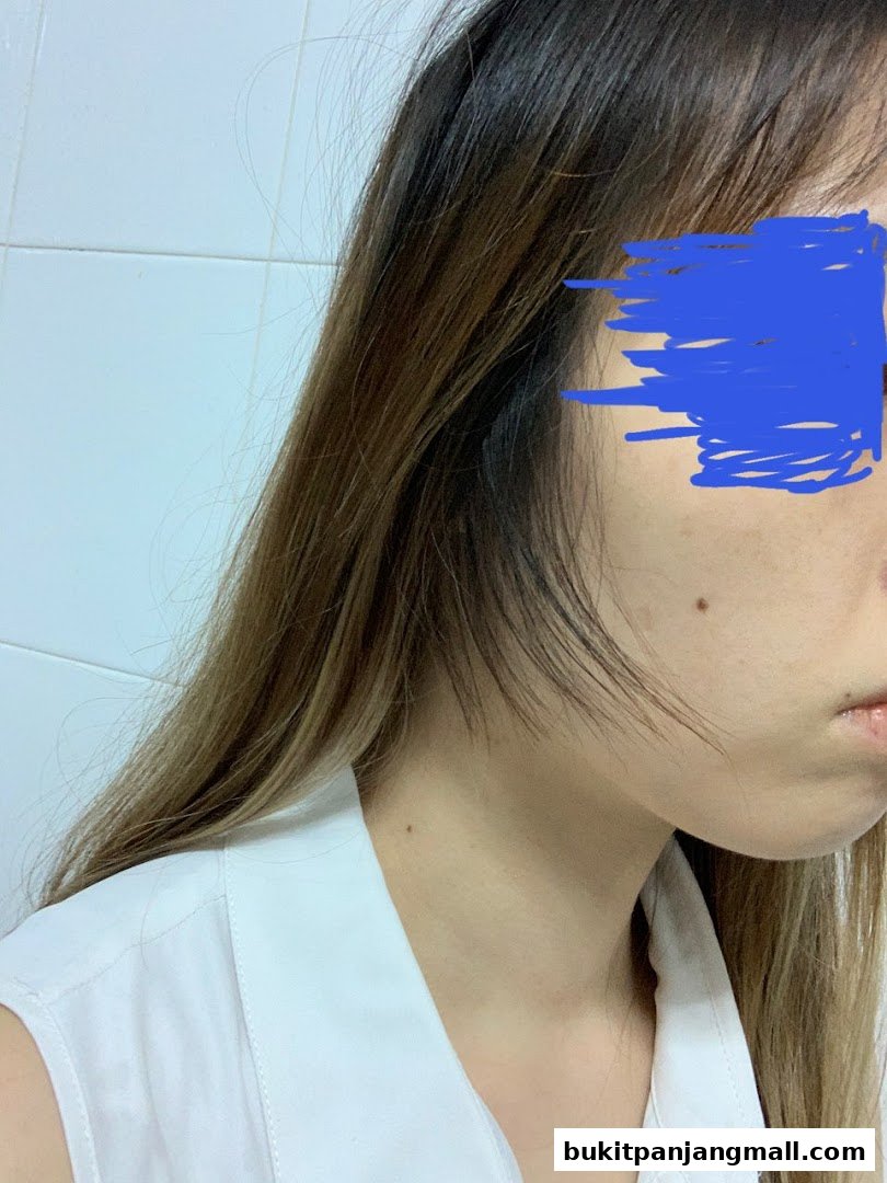 A close-up profile view of a person with long, layered brown hair and a white collared shirt.
