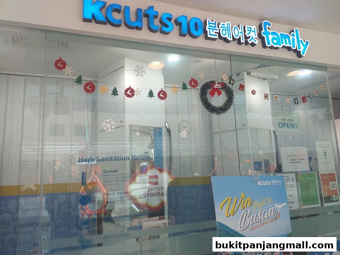 The storefront of Kcuts hair salon, decorated with festive holiday banners and a 'We Are Open' sign.
