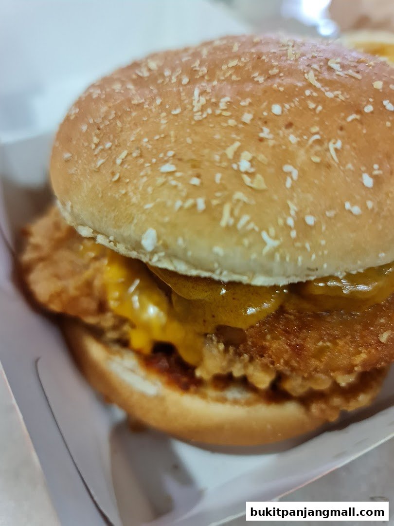 A close-up shot of a delicious KFC chicken burger with melted cheese.