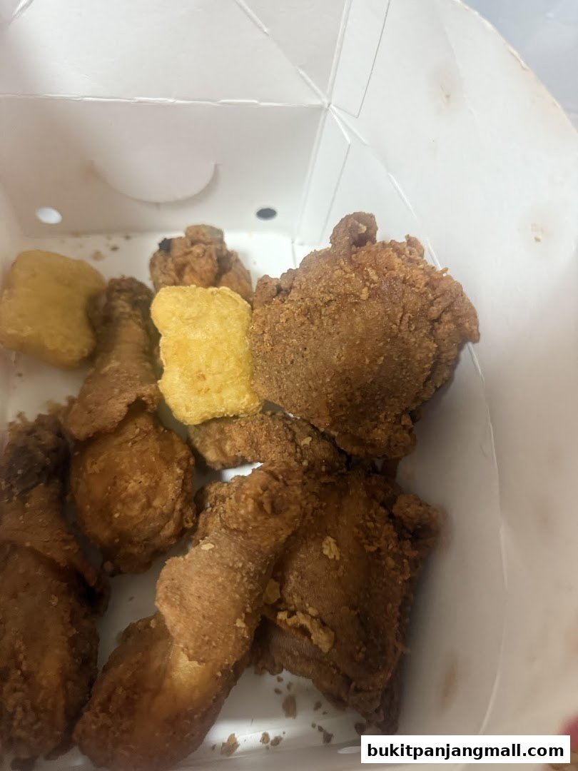 A box filled with crispy fried chicken pieces and golden nuggets.