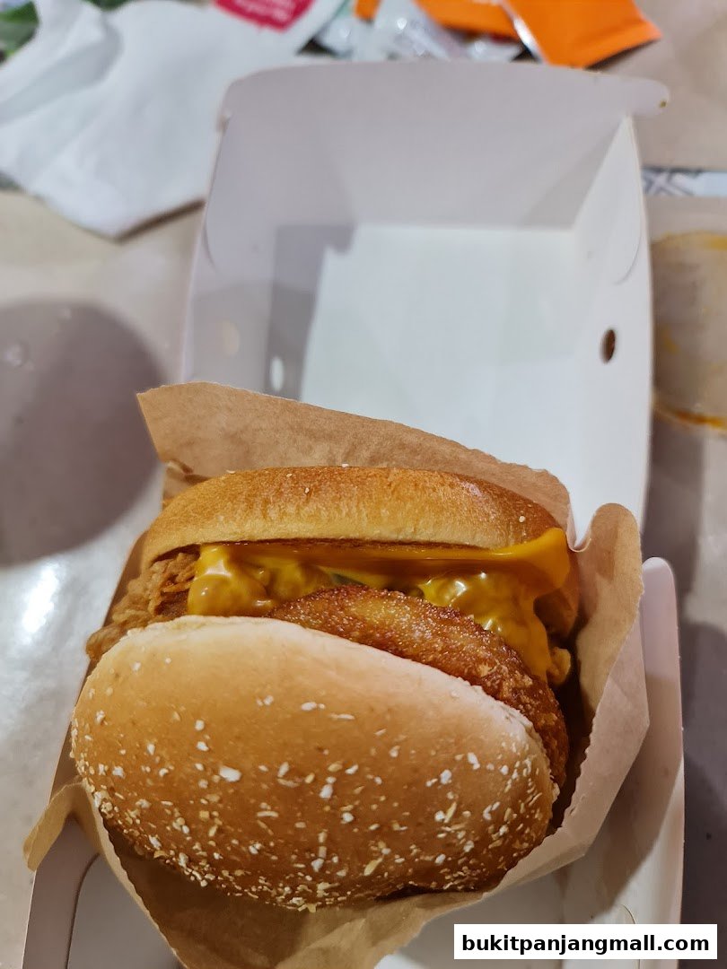 A close-up shot of a delicious KFC chicken burger with melted cheese.