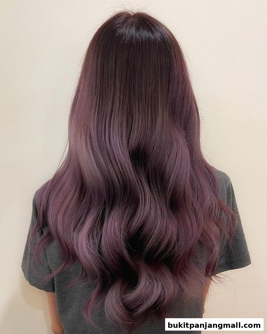 A person's back showcasing long, wavy hair with a beautiful purple ombre.