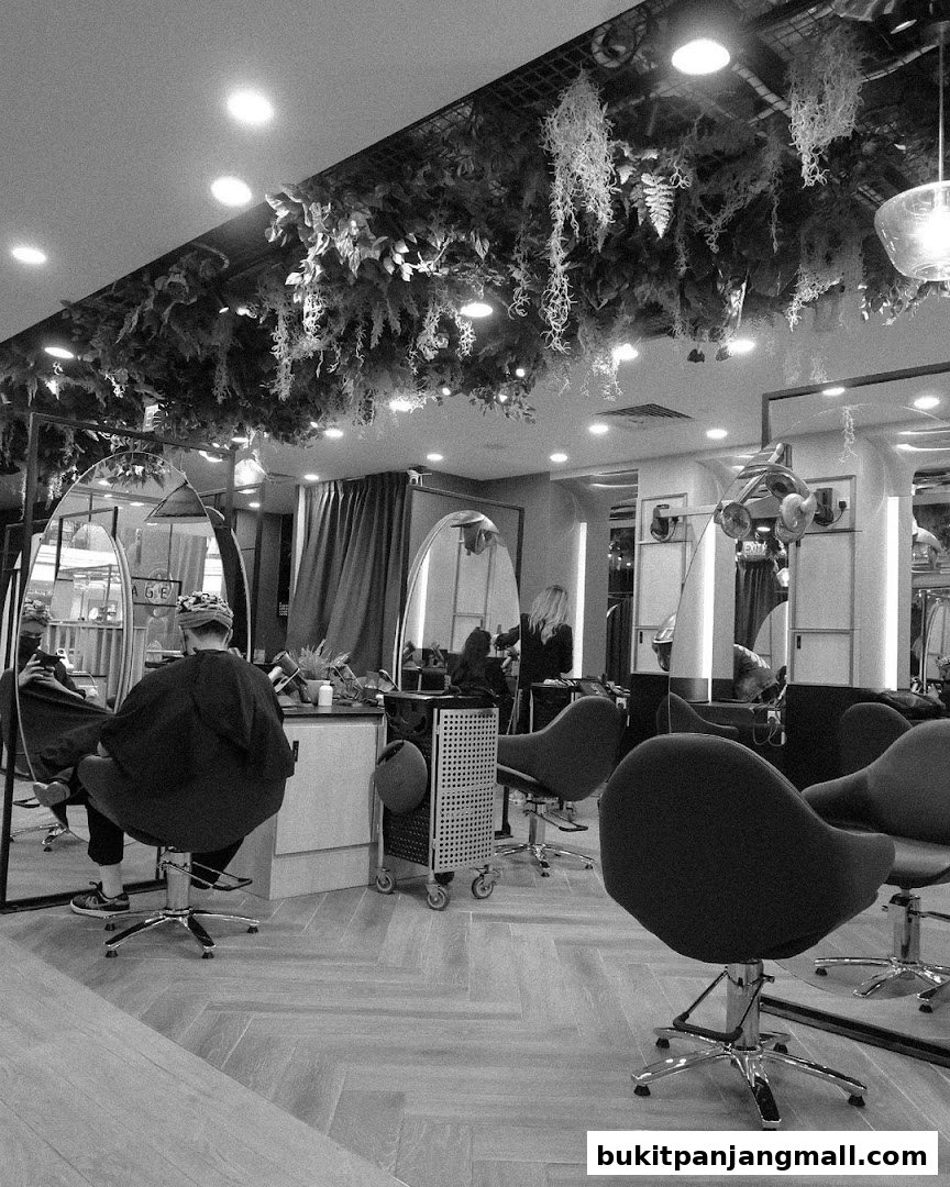 Interior of a modern hair salon with styling chairs, mirrors, and lush ceiling greenery.
