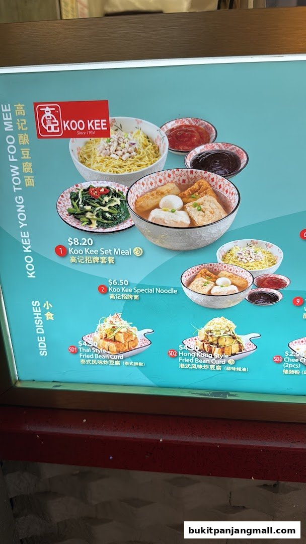 A menu board for Koo Kee Yong Tow Foo Mee, showcasing various noodle dishes and side dishes.