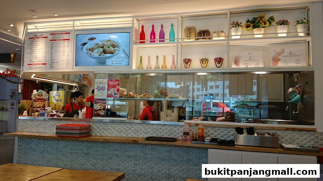 A view of the Koo Kee shop counter with staff, menu, and food display.