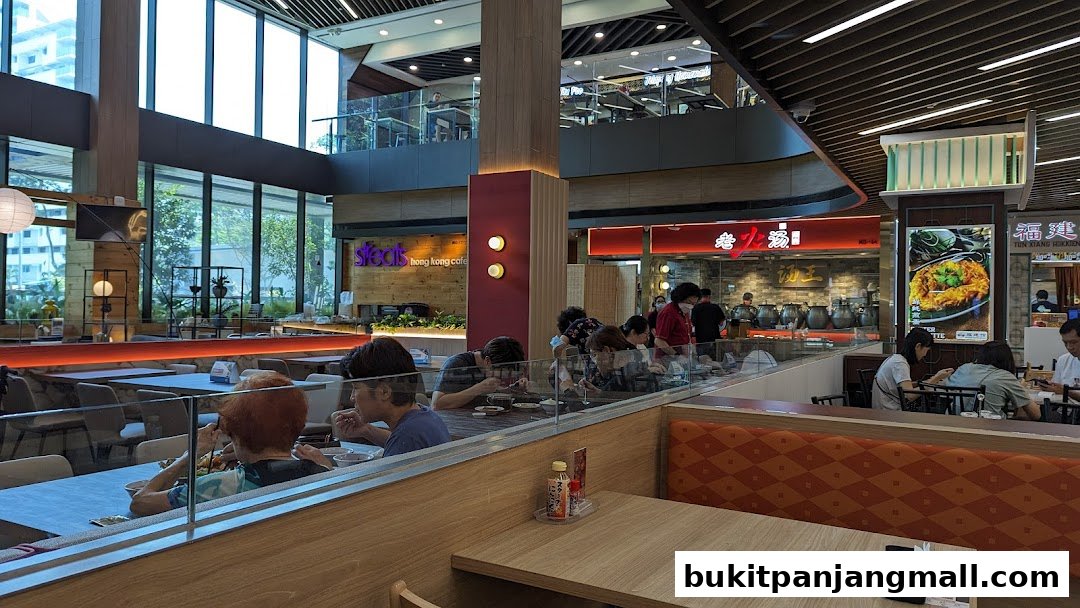 Diners enjoy meals at tables in a modern food court with various restaurants visible.