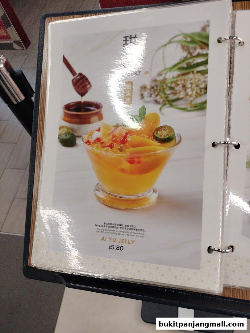 A menu item featuring Ai Yu Jelly with mango and other fruits, drizzled with honey.