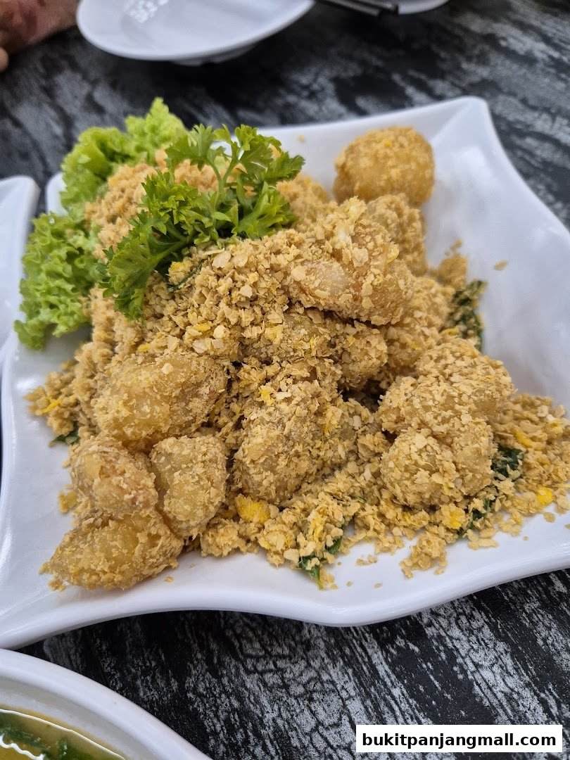 A plate of crispy fried food coated in crumbs, garnished with lettuce and parsley.