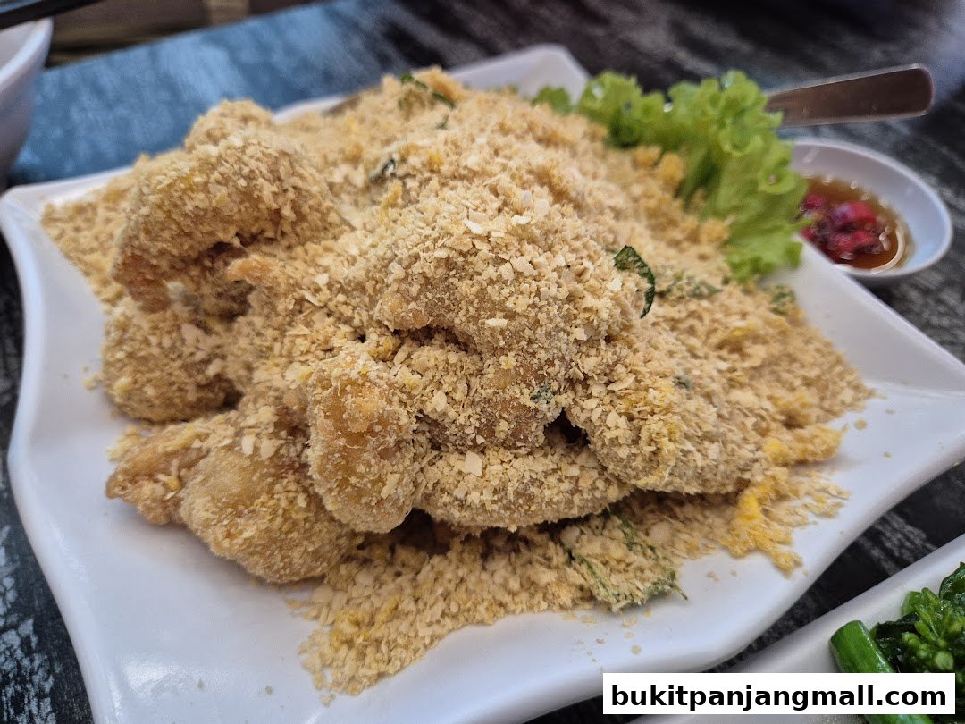 A plate of crispy fried shrimp covered in breadcrumbs and herbs, served with lettuce and dipping sauce.